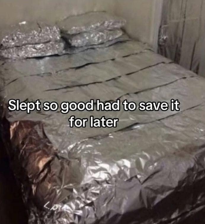 A surreal and funny viral photo of a bed and pillows that have been completely wrapped in aluminum foil like leftovers.