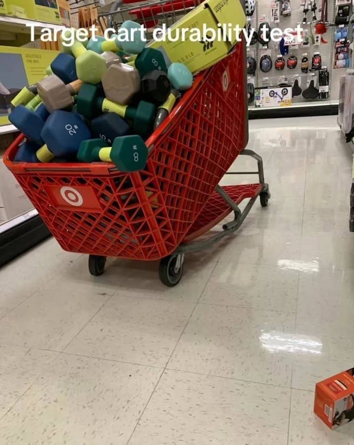 A funny photo of a red Target shopping cart filled to the absolute brim with heavy dumbbells as a "durability test."
