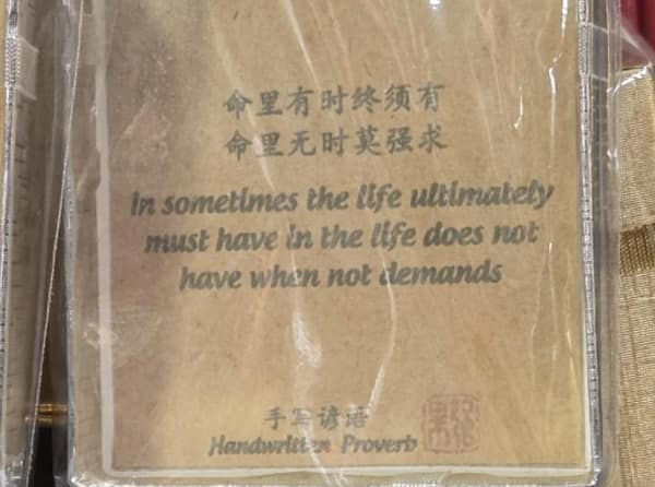 Souvenir plaque with Chinese characters and stilted English: “in sometimes the life ultimately must have… when not demands.”