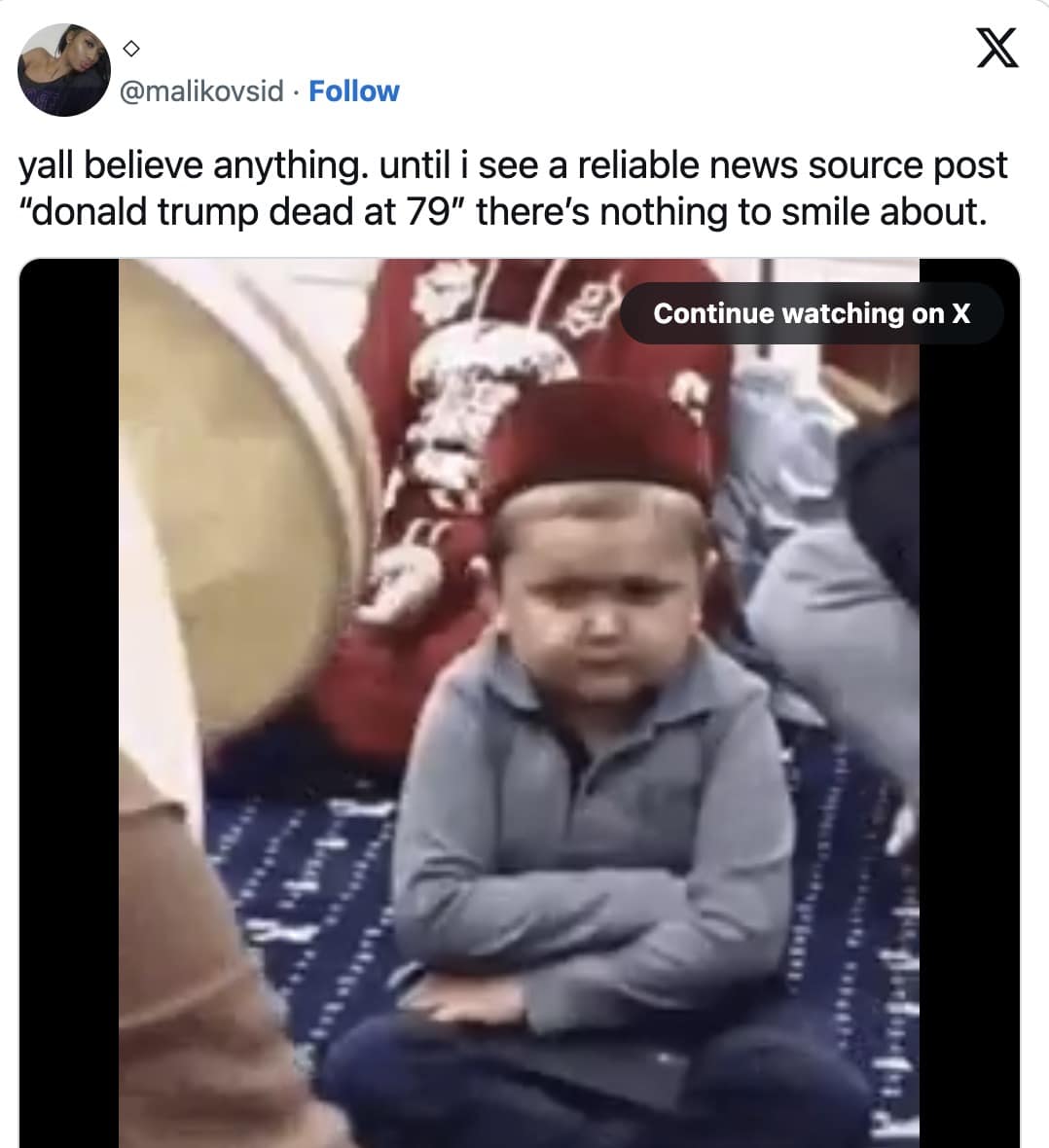 Video still of a pouting child seated with arms crossed at an event.