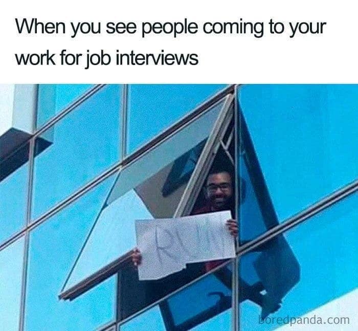 A funny work meme of an employee holding a "RUN" sign out a window to warn job interviewees.