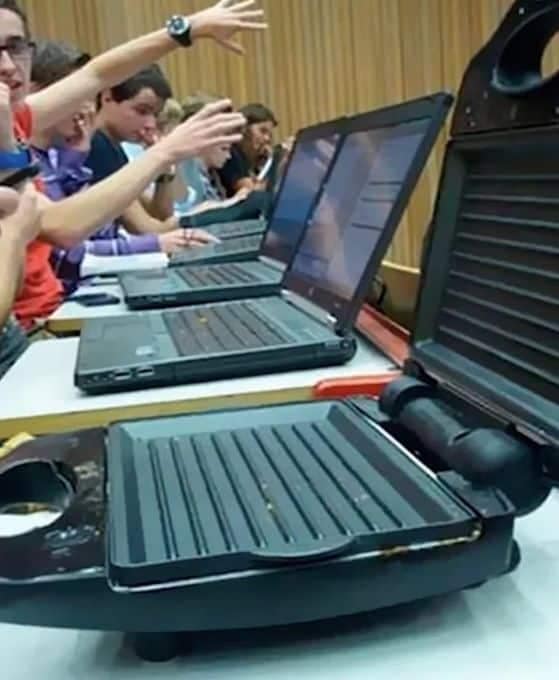 A hilarious photo taken in a university lecture hall, where a student in the front row is using a George Foreman grill instead of a laptop.