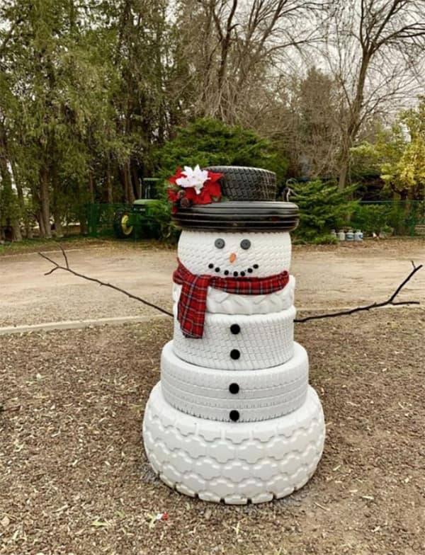 A snowman made from large, stacked white tires, a very creative and resourceful yard art DIY win.