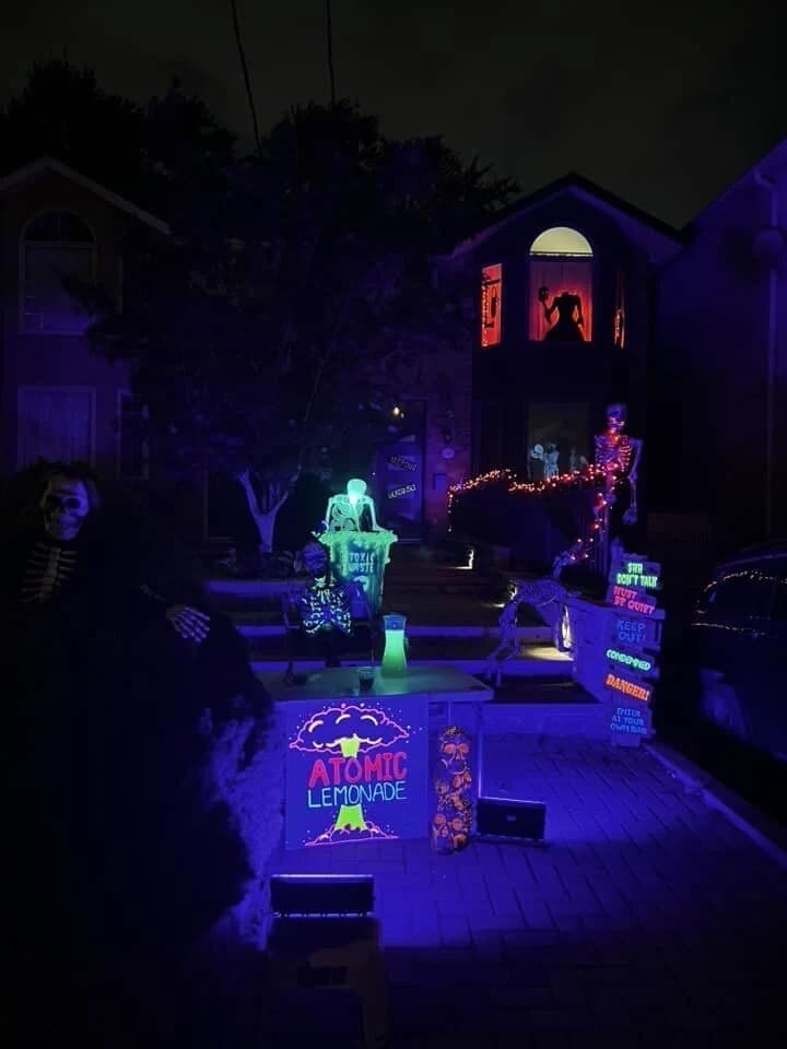 An amazing halloween house using blacklights to create a glowing "Atomic Lemonade" stand run by skeletons