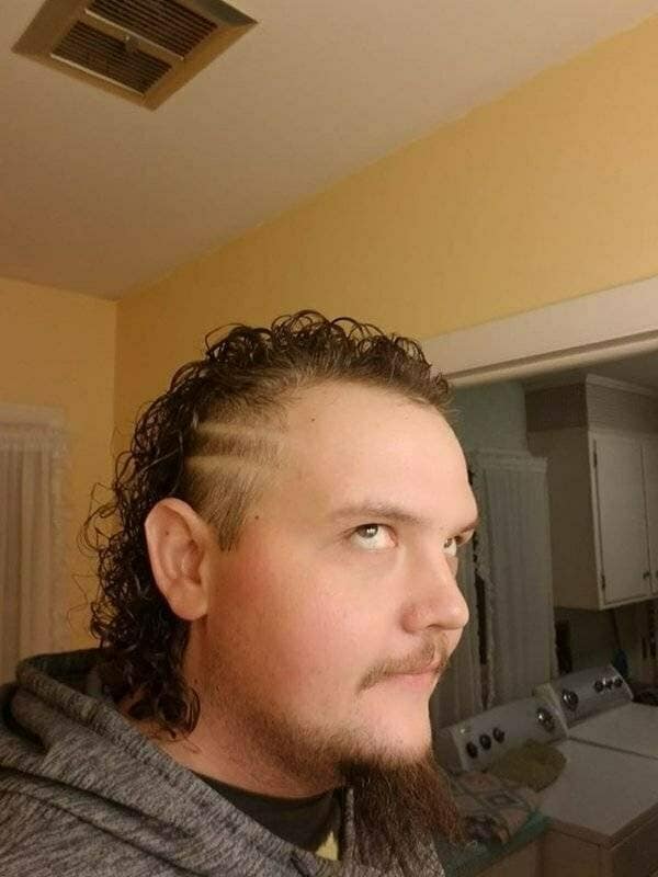 One of the most unfortunate bad haircuts, a curly mullet with racing stripes shaved into the side