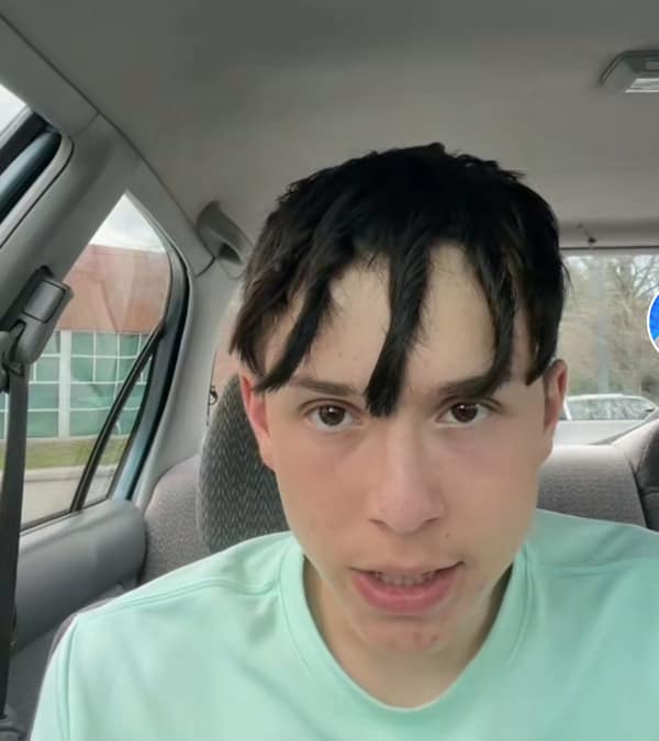 A young man with one of the worst haircut fails, featuring thick, separated bangs.