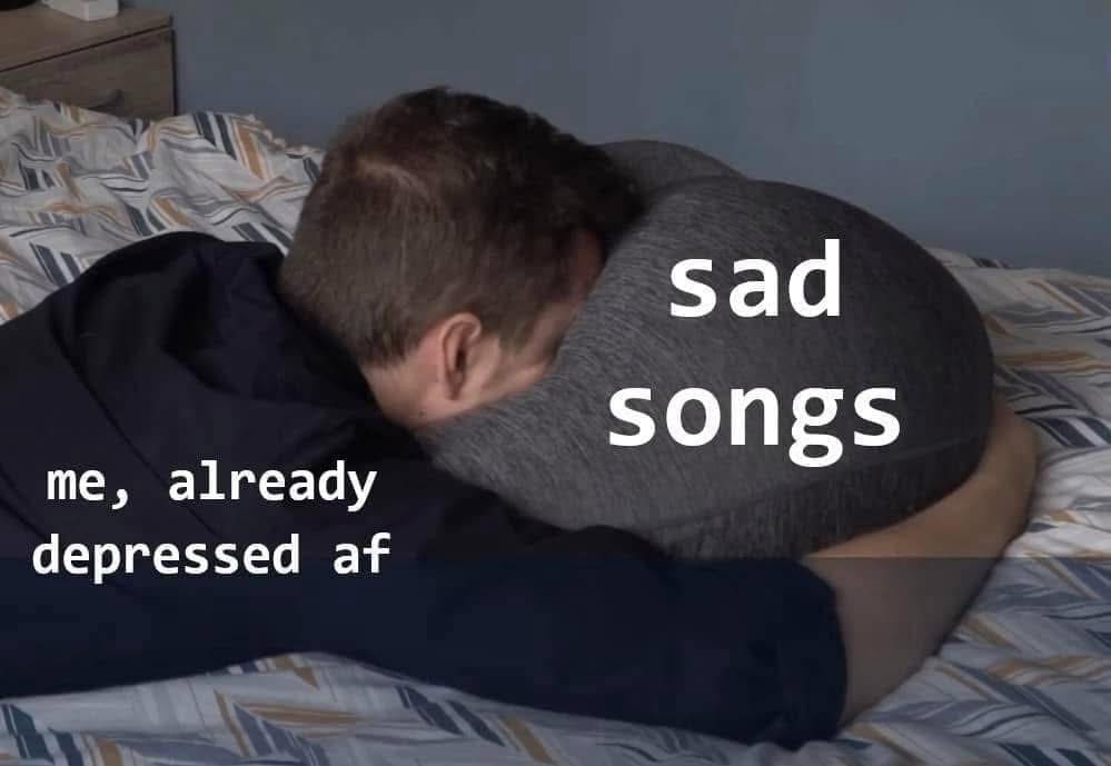 An old meme showing a depressed person hugging a pillow labeled "sad songs."