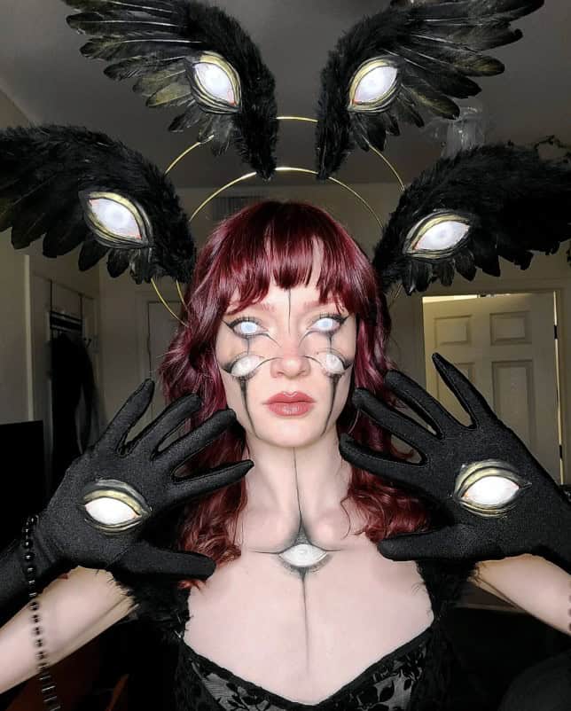 A woman wearing an intricate and unsettling biblically accurate angel costume with multiple eyes.