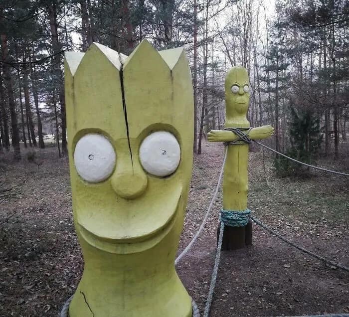 A cursed image featuring creepy, dilapidated wooden statues resembling Bart Simpson found in a forest.