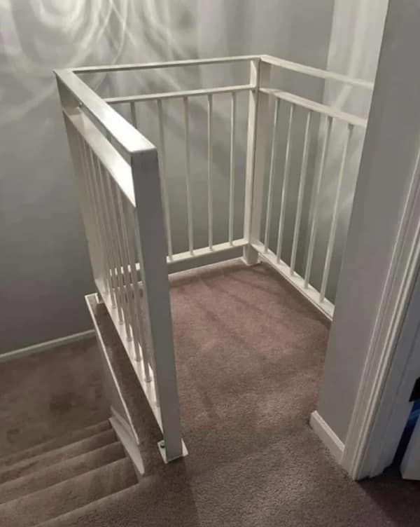 A funny home renovation fail where a landing at the top of a staircase has been completely railed off, creating a human-sized cage.