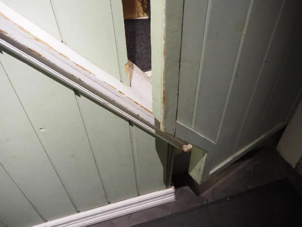 A DIY fail showing a staircase handrail that leads directly into a solid wall, making it completely useless.