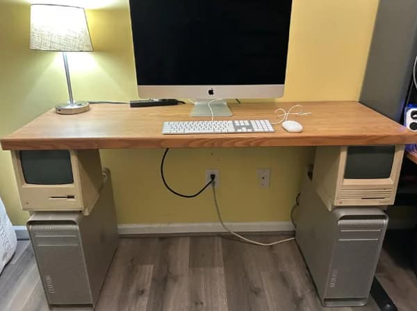 A DIY desk made from vintage Apple computers, including old Mac towers and monitors as legs.