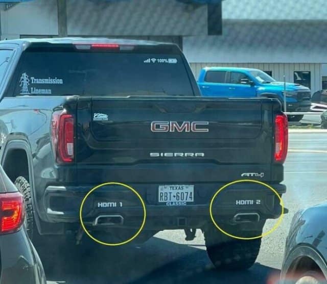 A nerdy and funny bumper sticker labeling the dual exhaust pipes on a truck as "HDMI 1" and "HDMI 2."