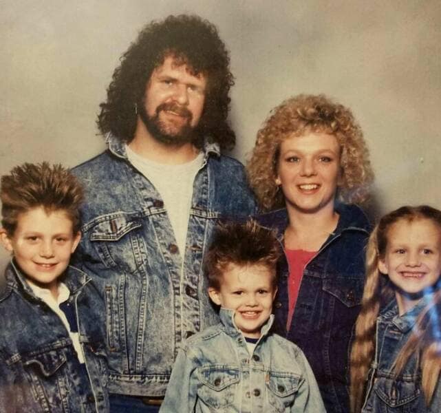 Epic 80s/90s family portrait featuring big hair, mullets, spiked styles, and matching denim jackets.