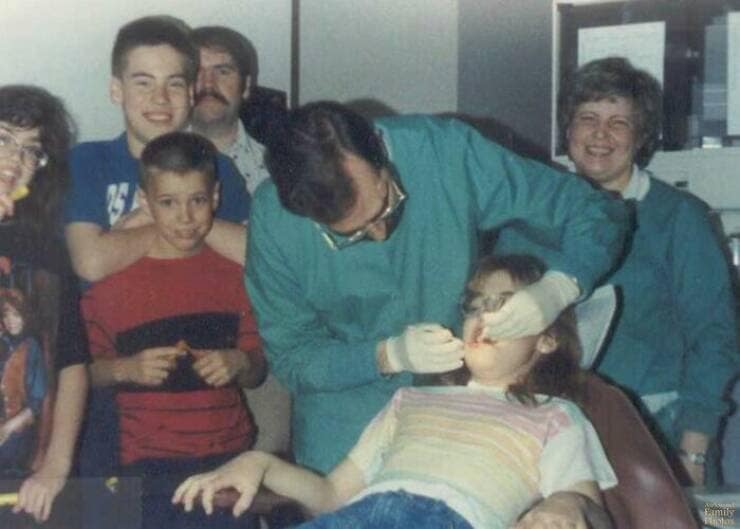 Extremely awkward family photo taken inside the dentist's office with everyone watching a child's dental check-up