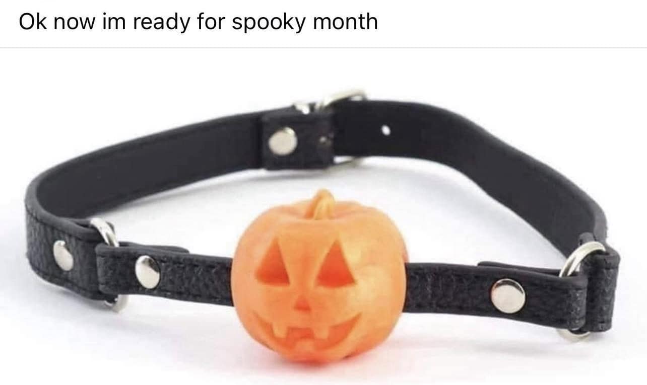 A BDSM ball gag where the ball has been replaced with a small, carved jack-o'-lantern for Halloween.