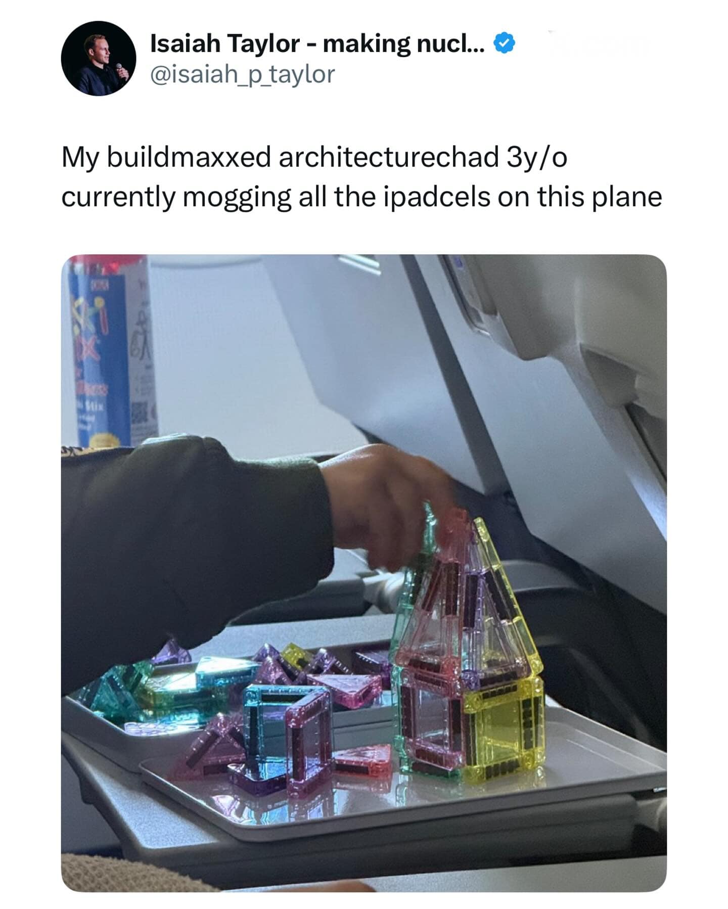 A tweet using niche internet slang to praise a toddler building with magnetic tiles on an airplane.
