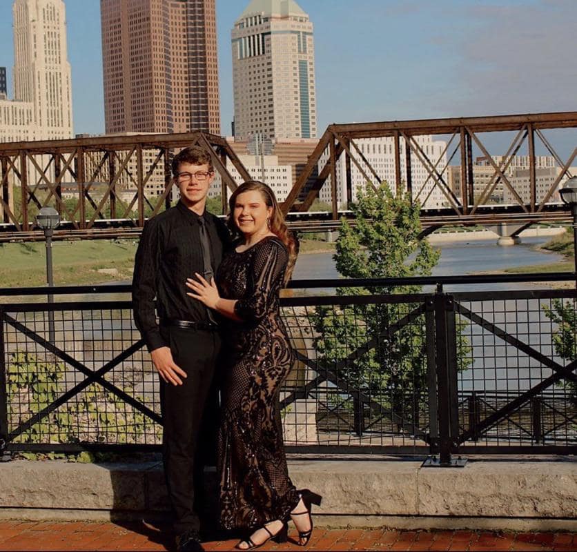 Funny photoshop fail showing a couple's prom photo where the background removal left floating hands behind them