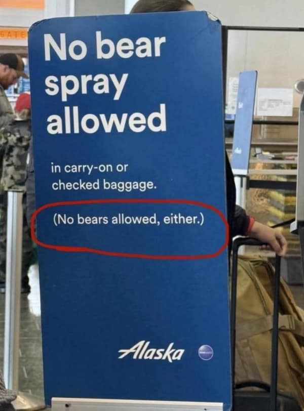 An Alaska Airlines sign that humorously clarifies that neither bear spray nor actual bears are allowed on planes.