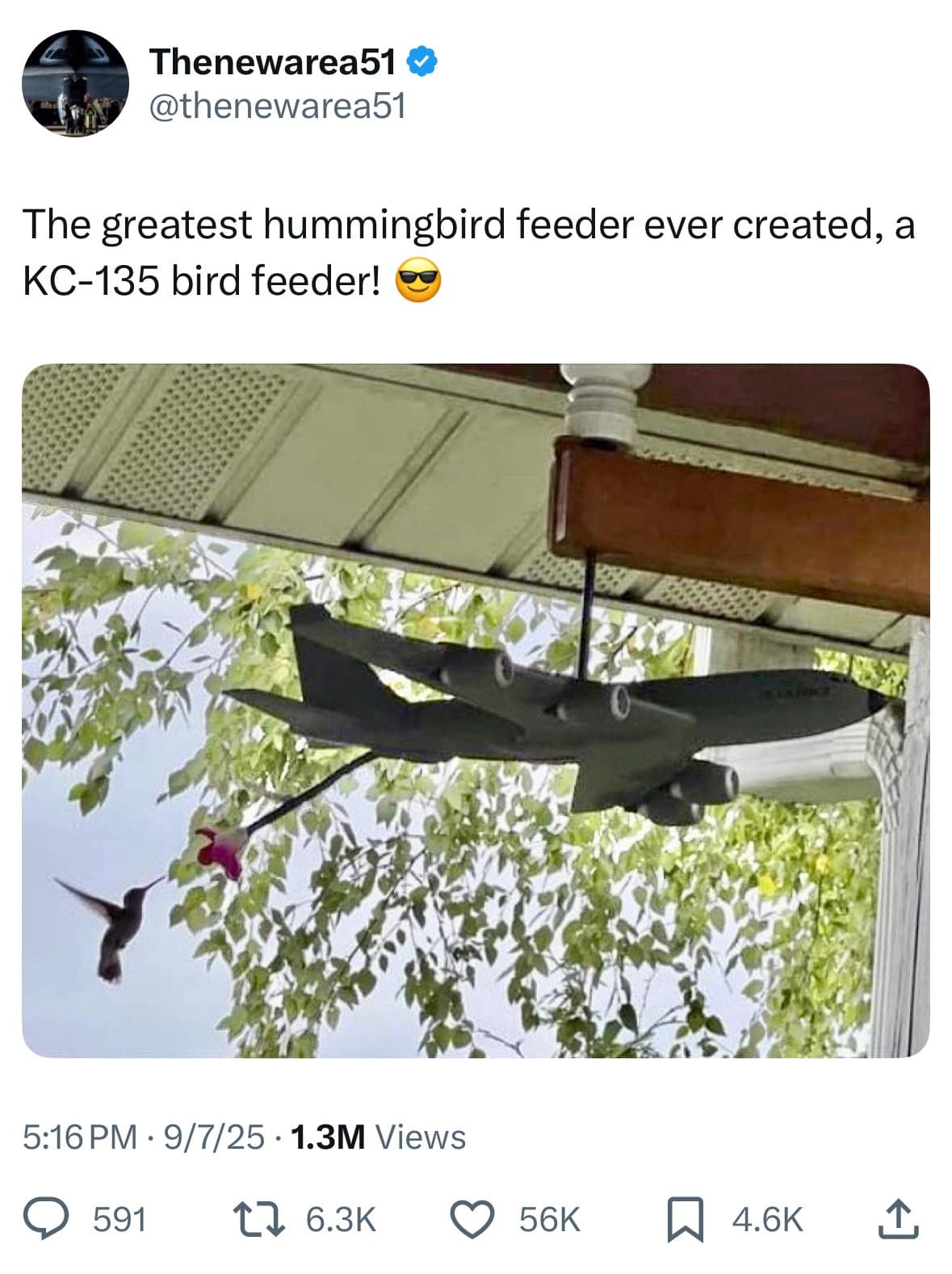 A creative hummingbird feeder shaped like a KC-135 refueling plane, feeding a hummingbird mid-air.