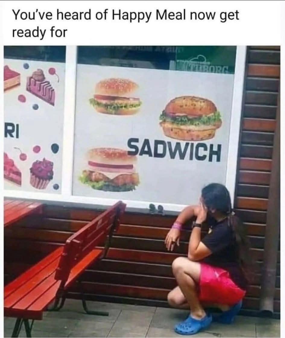 A funny pic of a person looking sad next to a restaurant advertising a "Sadwich."