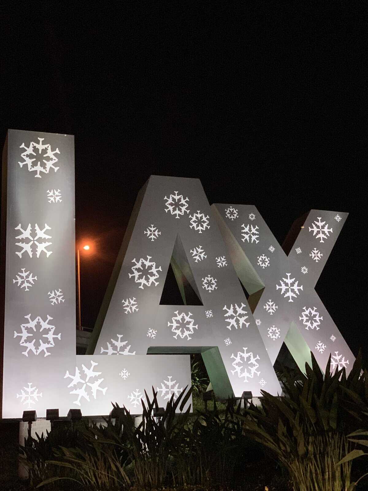 Funny sign showing the large iconic LAX airport letters decorated with snowflake lights for winter