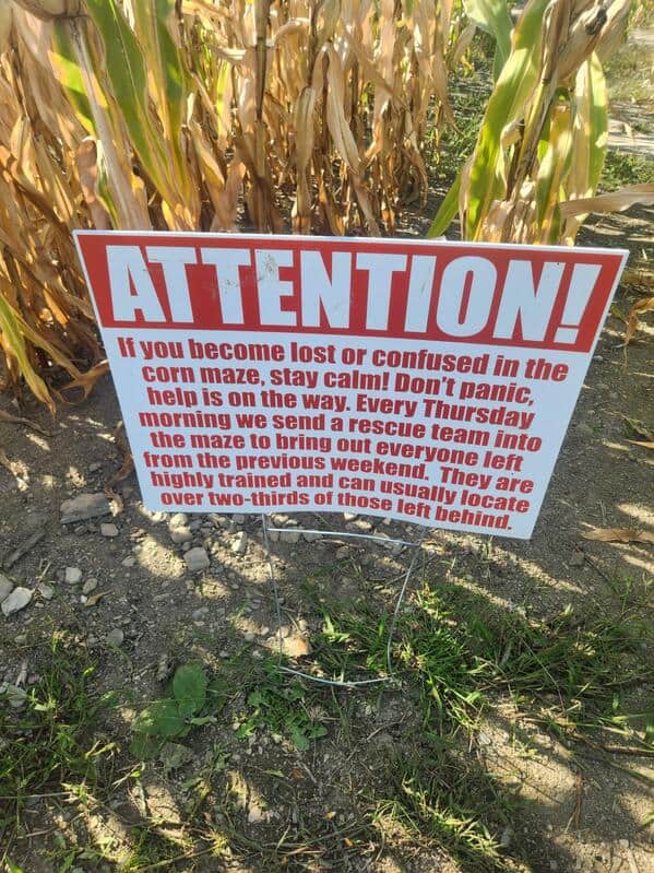 A dark humor corn maze sign warning that the rescue team only finds two-thirds of lost people.