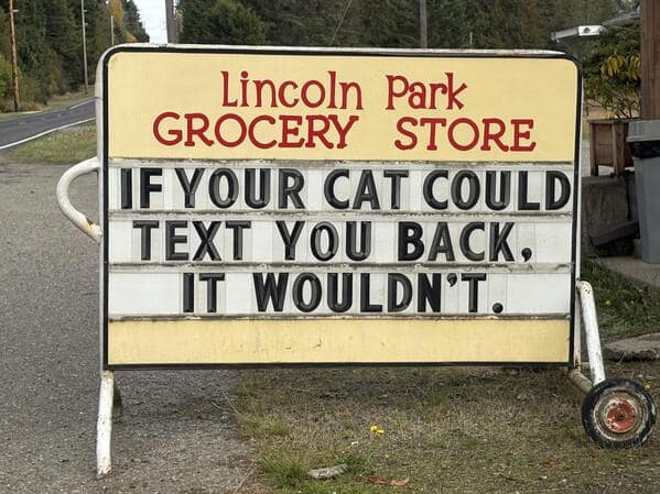 A grocery store sign stating that if your cat could text you back, it wouldn't.