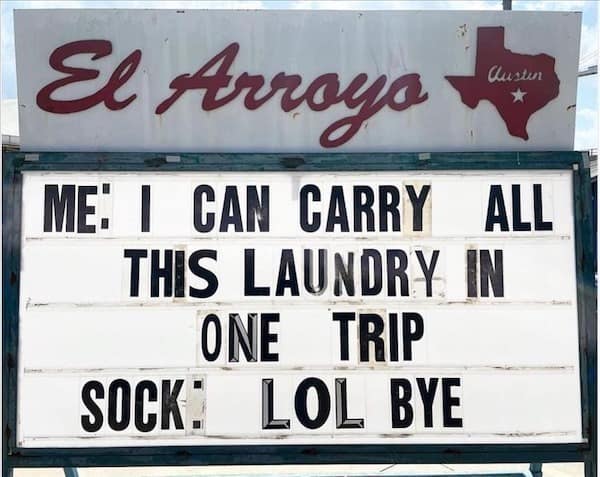 A funny grumpy meme on an El Arroyo sign about a sock falling during a laundry trip.