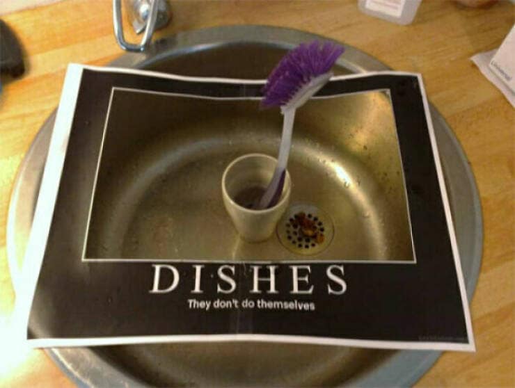 A motivational-style poster placed in a dirty sink reading, "DISHES: They don't do themselves."