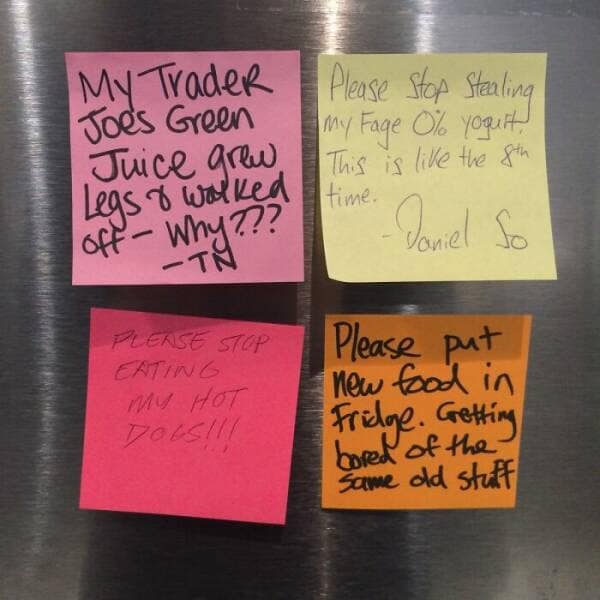 A collection of four angry and sarcastic sticky notes on an office fridge about stolen food.