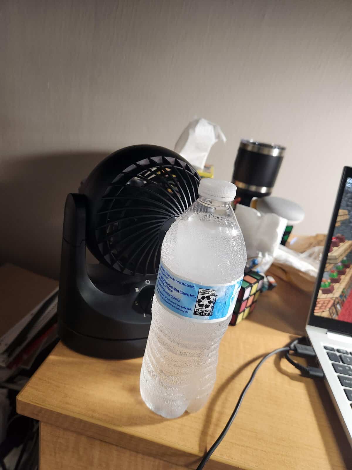 A classic example of redneck ingenuity, showing a frozen water bottle placed in front of a fan to create a DIY air conditioner.