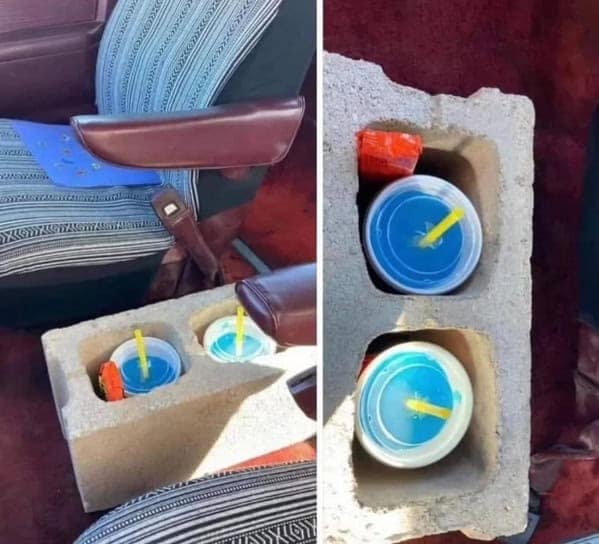 A hilarious example of redneck ingenuity, where a heavy cinder block is being used as a very sturdy cupholder in a car.