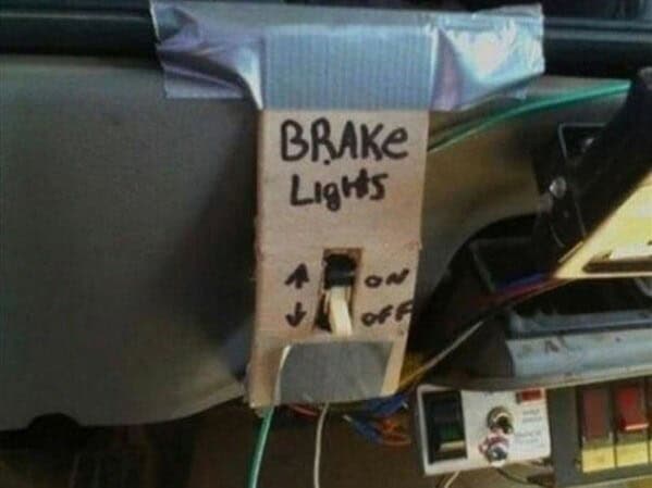 A terrifying example of redneck innovation: a handmade cardboard and duct tape switch for a car's brake lights.