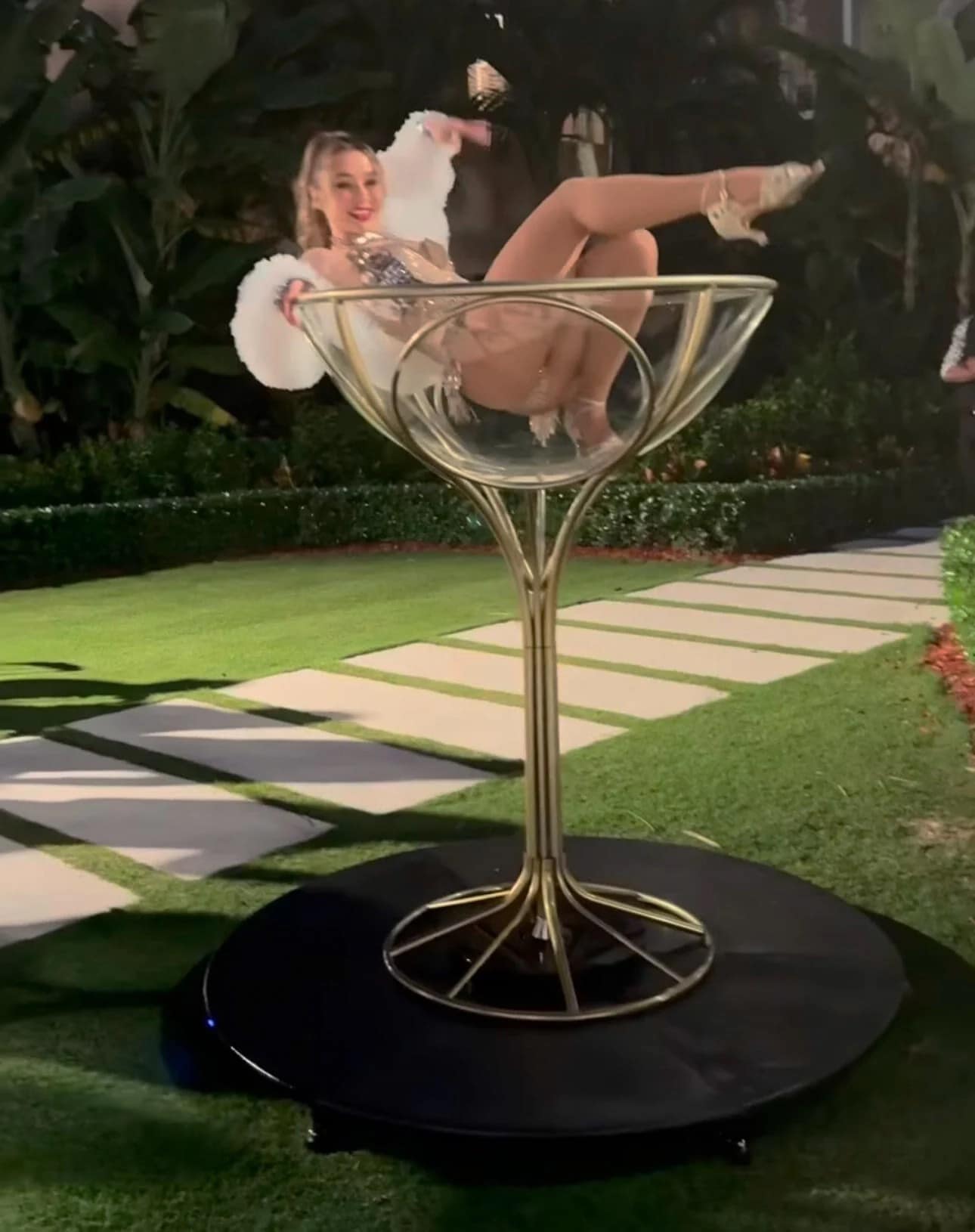 A photo from the Trump Great Gatsby party of a performer in a giant champagne glass.