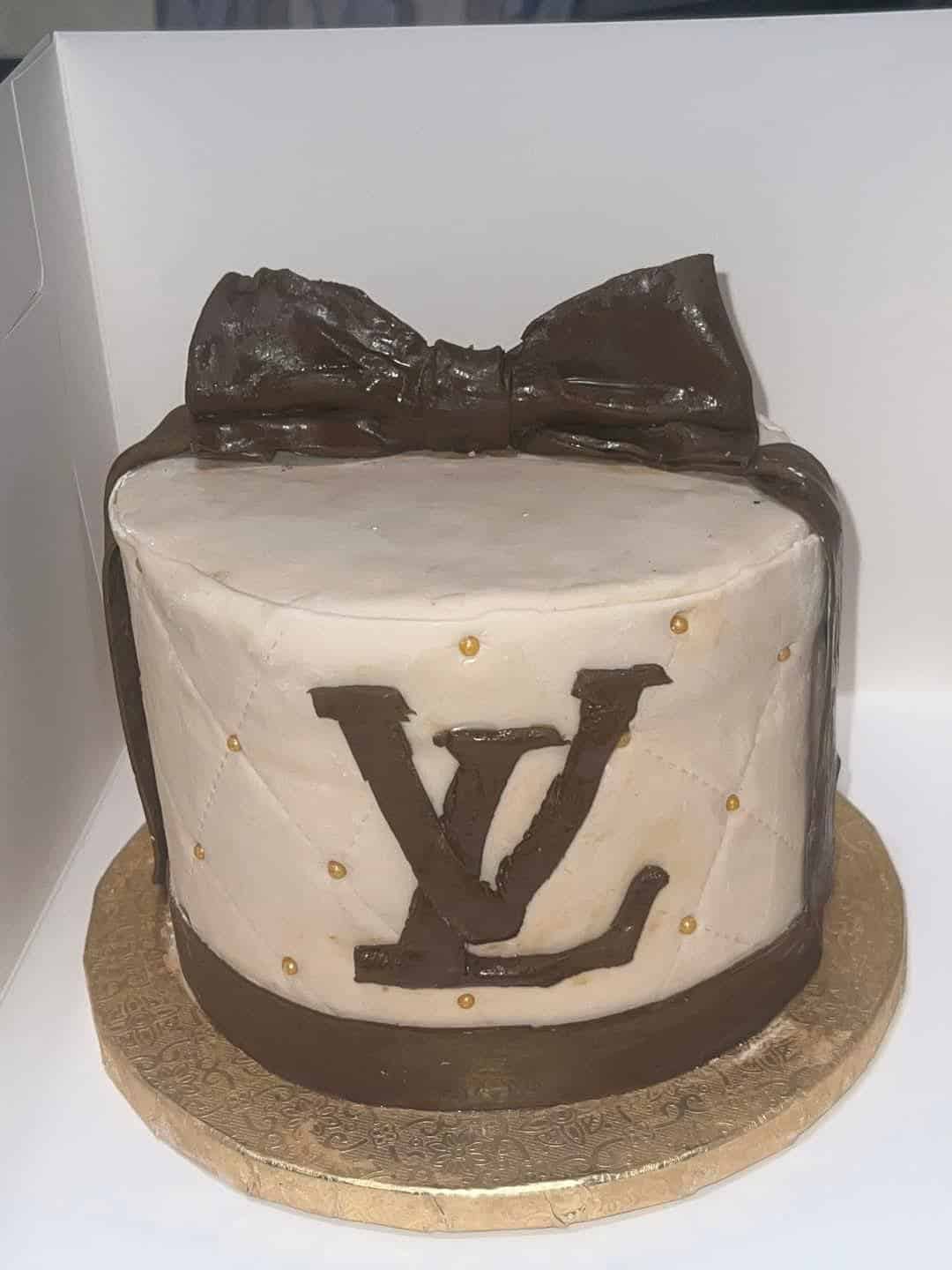 A failed attempt at a Louis Vuitton designer bag cake, with a lumpy brown bow and a poorly piped logo.