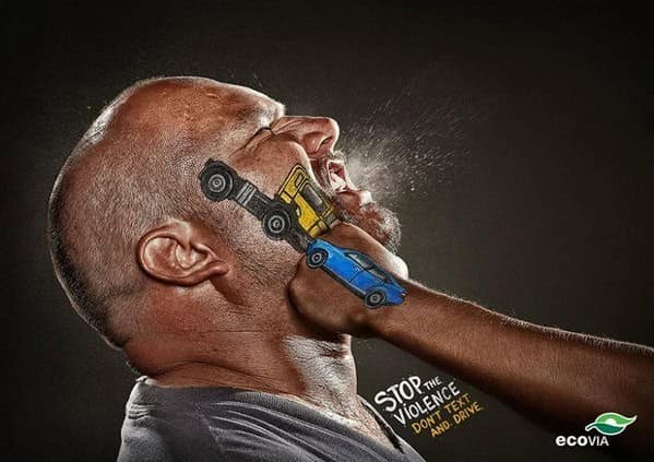 Face being punched by a fist painted like a car in a clever ad against texting and driving.