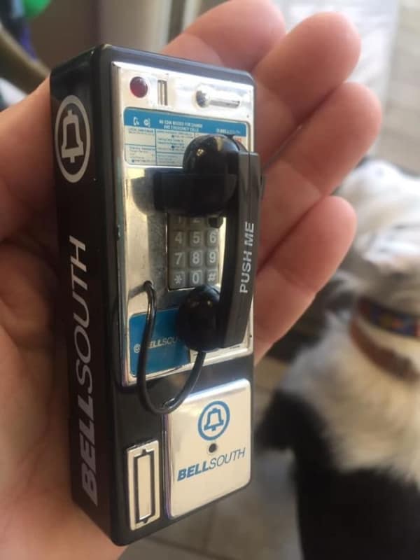 Tiny miniature vintage BellSouth payphone novelty item held in hand.