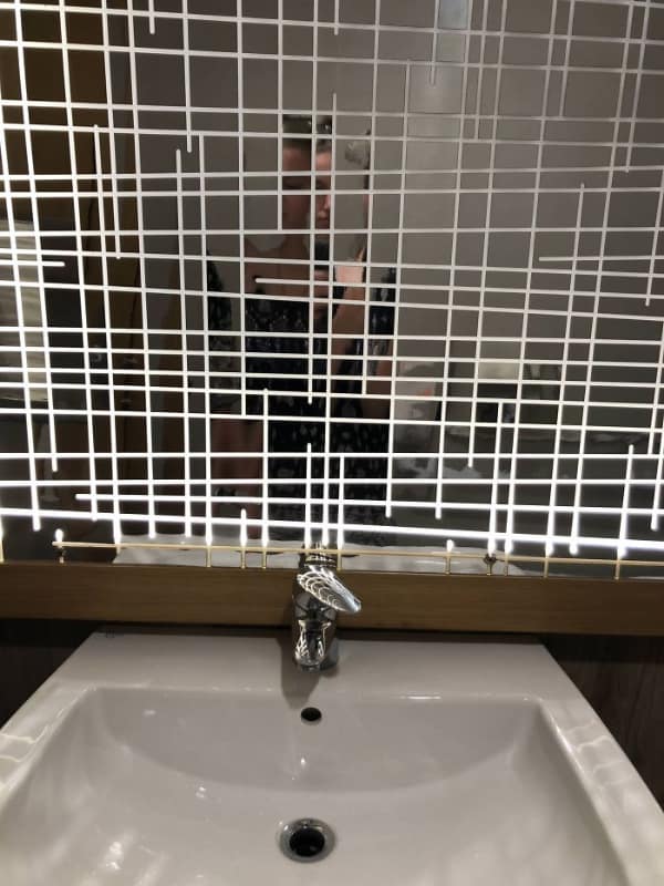 A bathroom mirror design fail obscured by a thick white grid pattern.