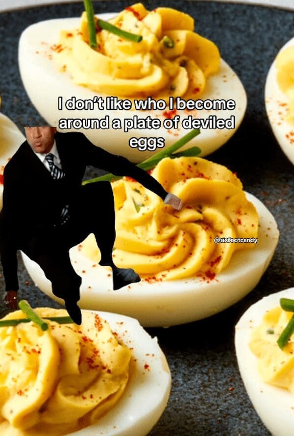 Man in a suit diving aggressively onto a giant platter of deviled eggs.
