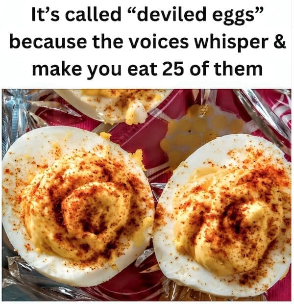 Close-up photo of two deviled eggs heavily sprinkled with paprika seasoning.