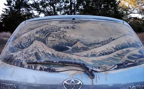 The Great Wave off Kanagawa recreated in dust on a Toyota Yaris hatchback window.