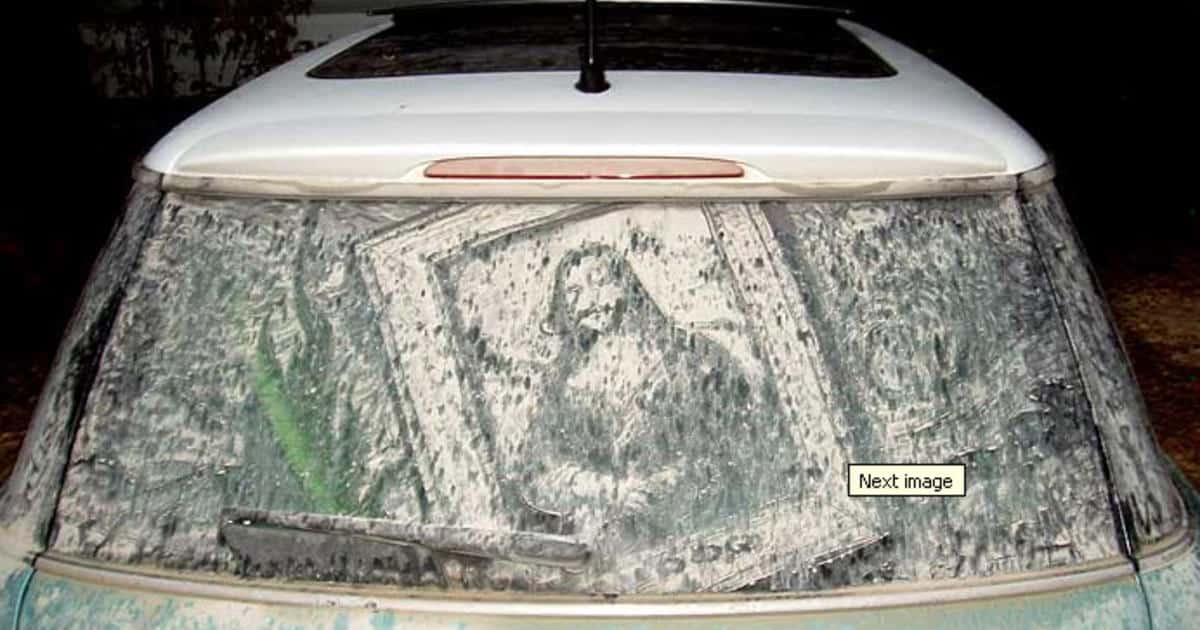 Detailed recreation of the Mona Lisa painted in dust on a white Mini Cooper window.