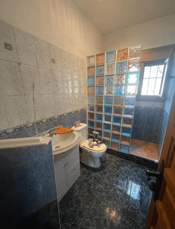 A bathroom diy fail where glass blocks cramp a toilet that barely fits.