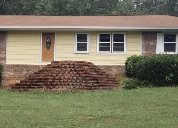 A construction diy fail showing brick stairs leading to a wall with no door.