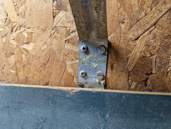 A structural diy fail where a bracket screw completely missed the wood stud.