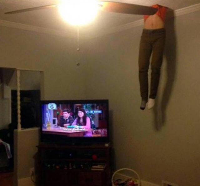 A cursed and funny fail showing a pair of mannequin legs stuck in the ceiling, with one leg through a fan.