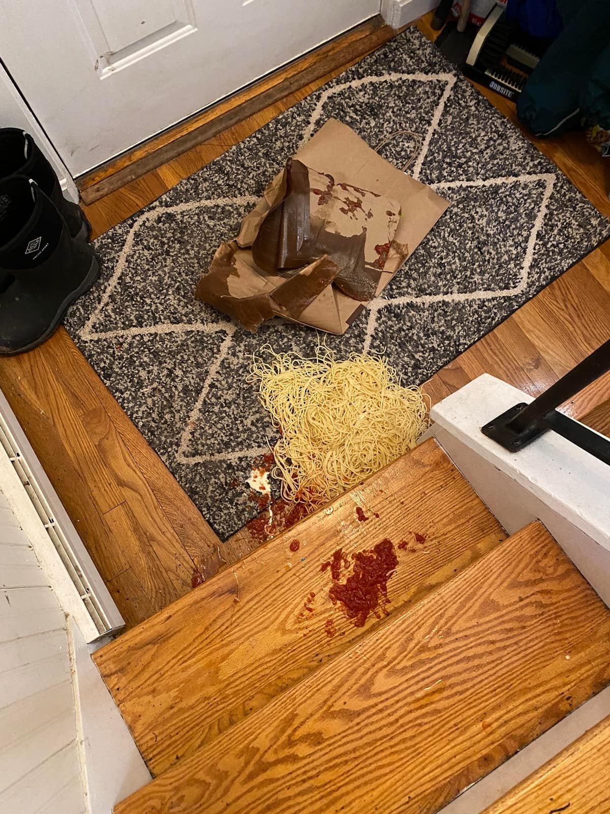 A funny fail of a full spaghetti dinner dropped on a rug and spilling down the wooden stairs