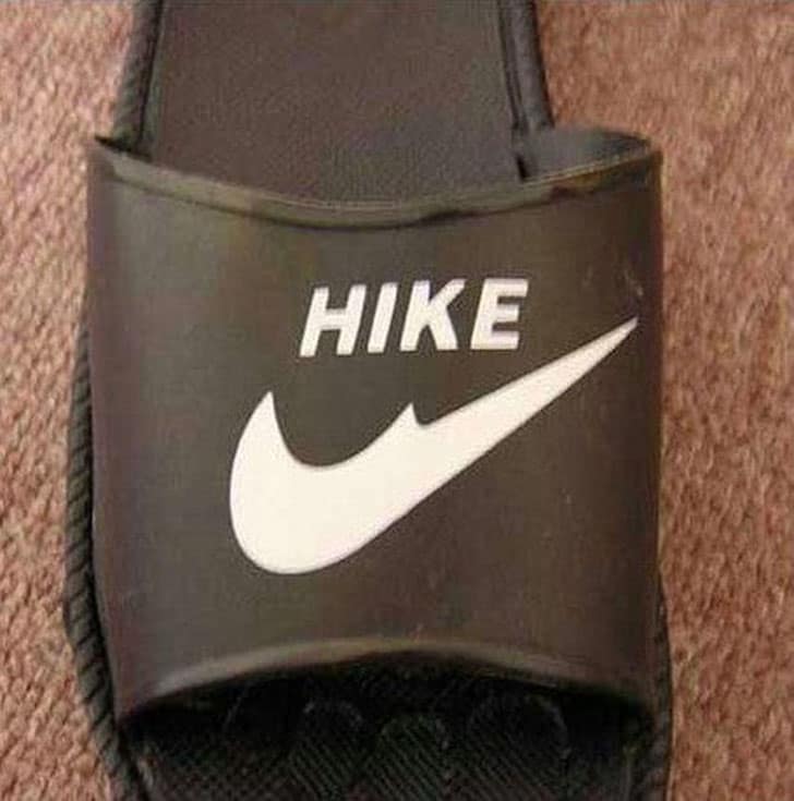 A hilarious "HIKE" sandal, a funny knock off brand of a Nike slide with a broken swoosh.