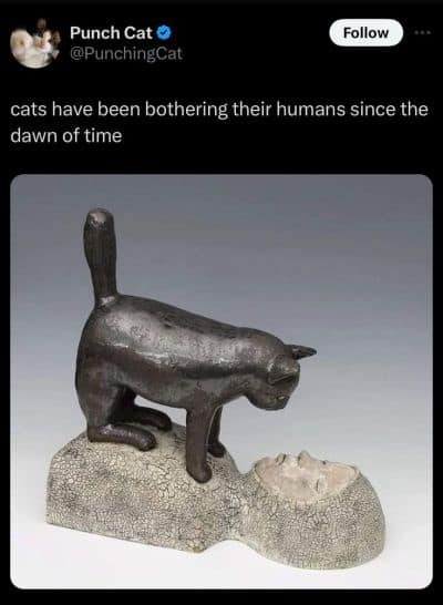 Bronze sculpture of a cat standing directly on a human face.